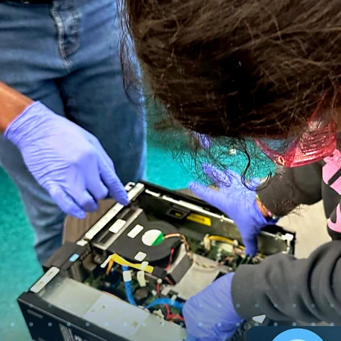 Student taking apart a desktop computer at a Tech Day